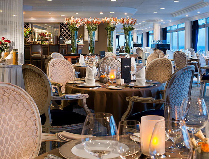Tables beside the windows in Azamara’s Aqualina specialty restaurant