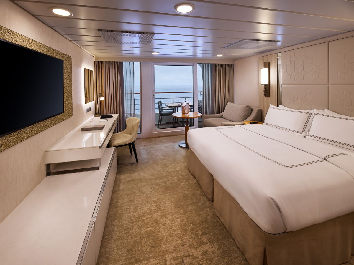 Azamara Continent Suite with bed, sitting area and private veranda