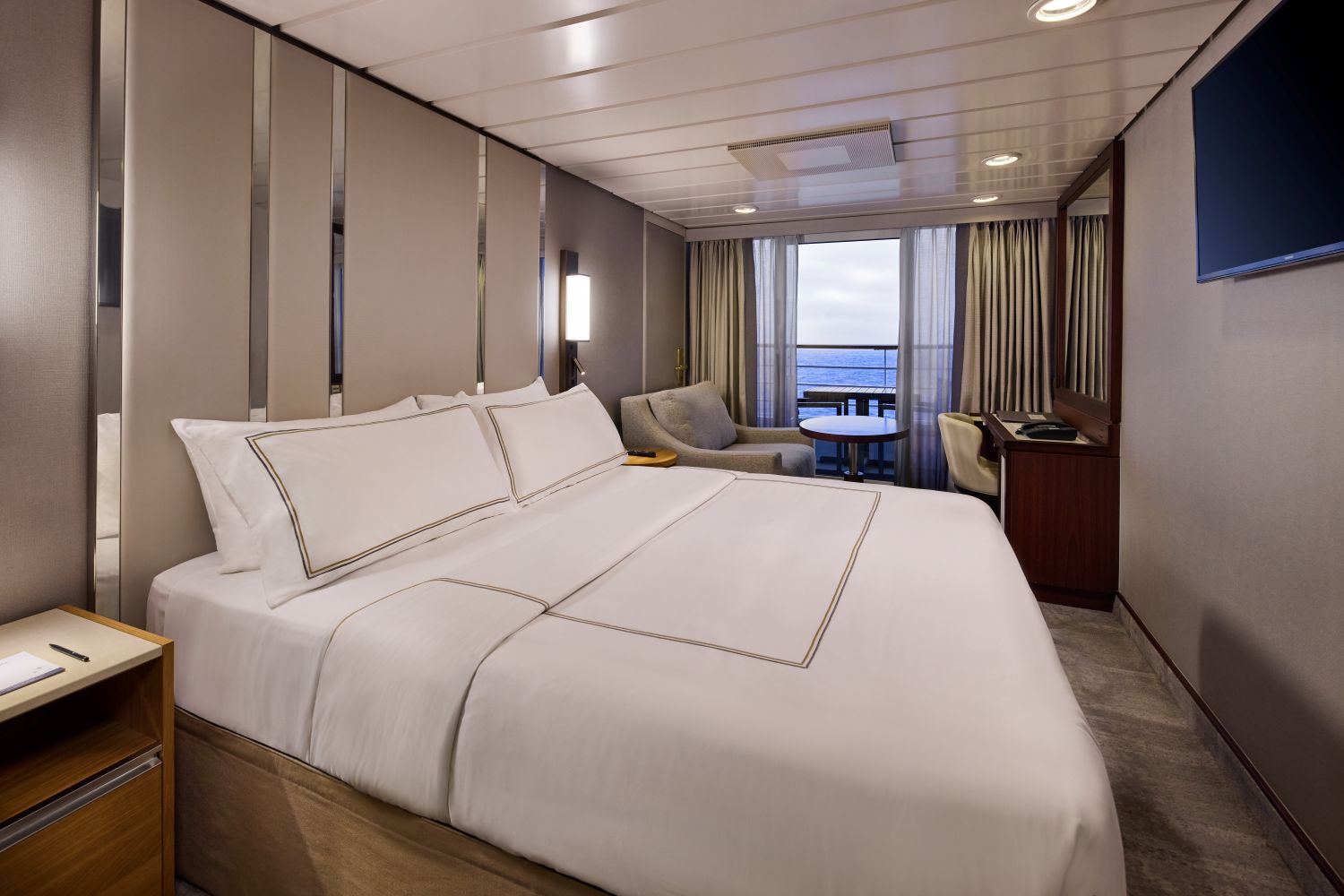 Azamara Veranda Stateroom with a bed and sitting area beside the balcony