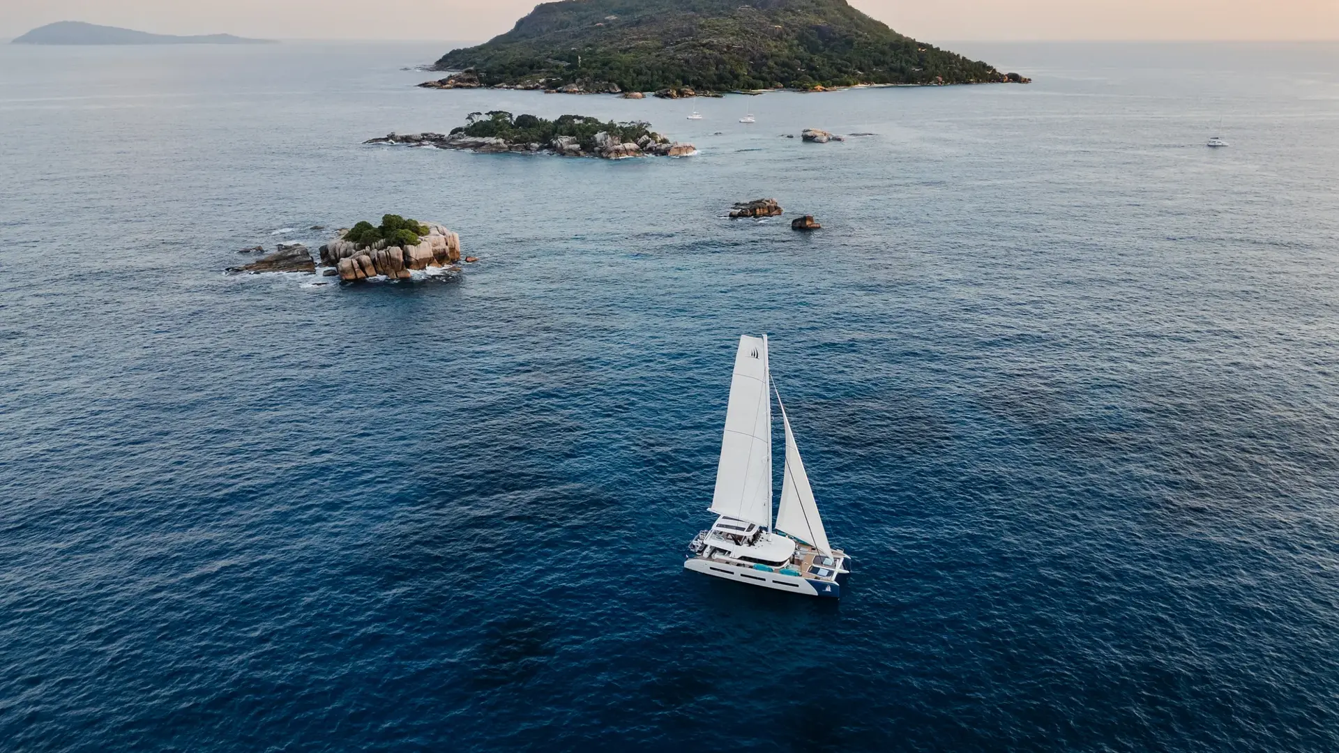 Spirit of Ponant sailing among the granite islands of the Seychelles.