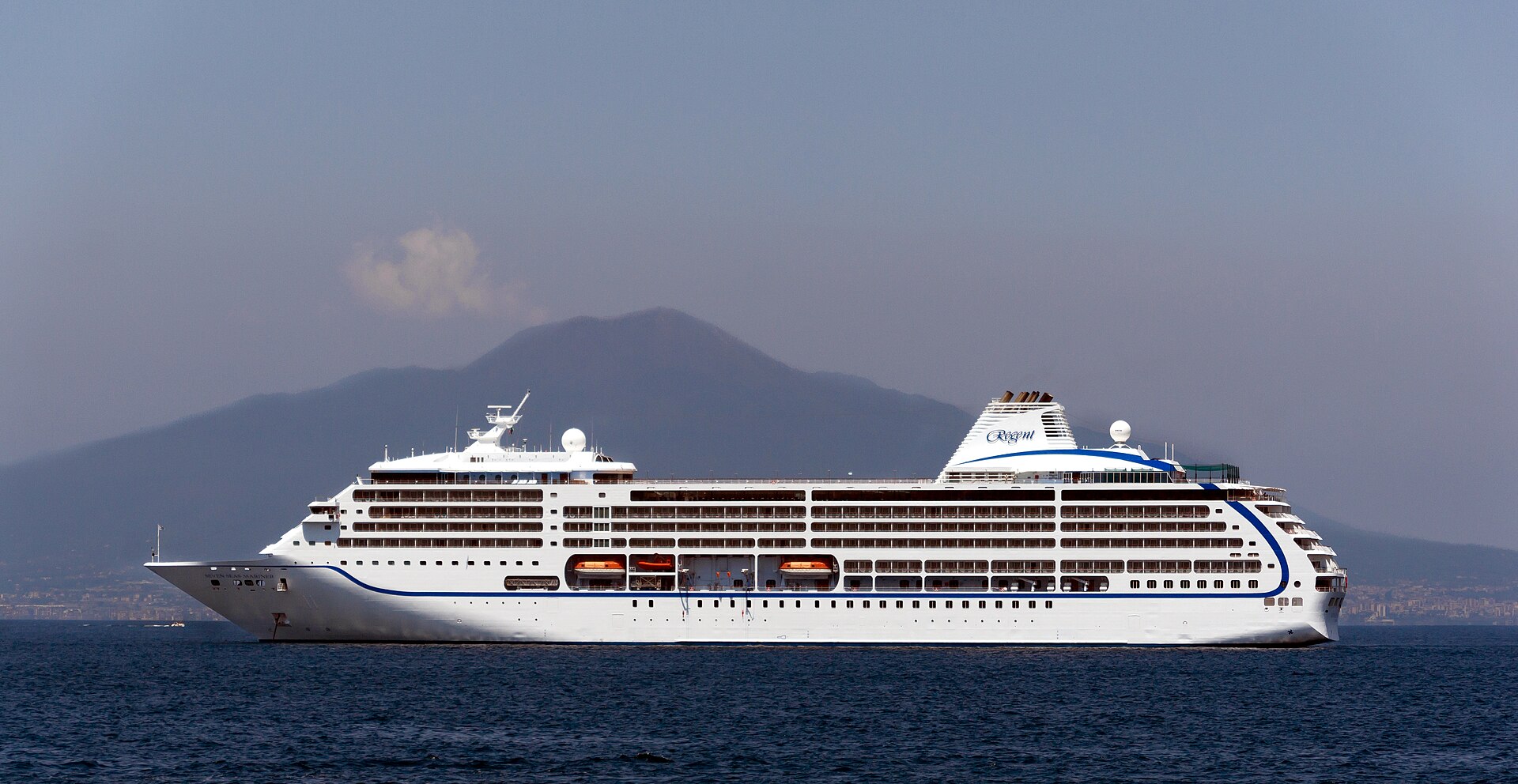 Seven Seas Mariner luxury cruise ship with Mount Vesuvius beyond