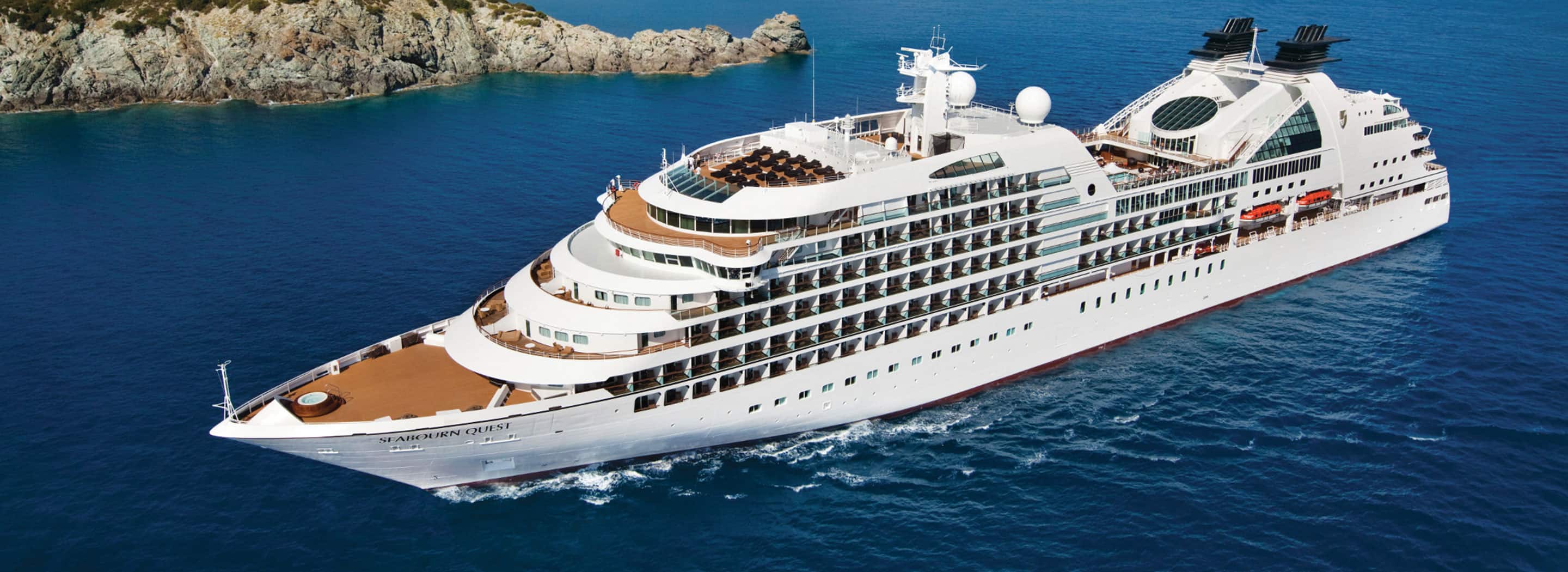 Seabourn Quest sailing along a rocky coastline