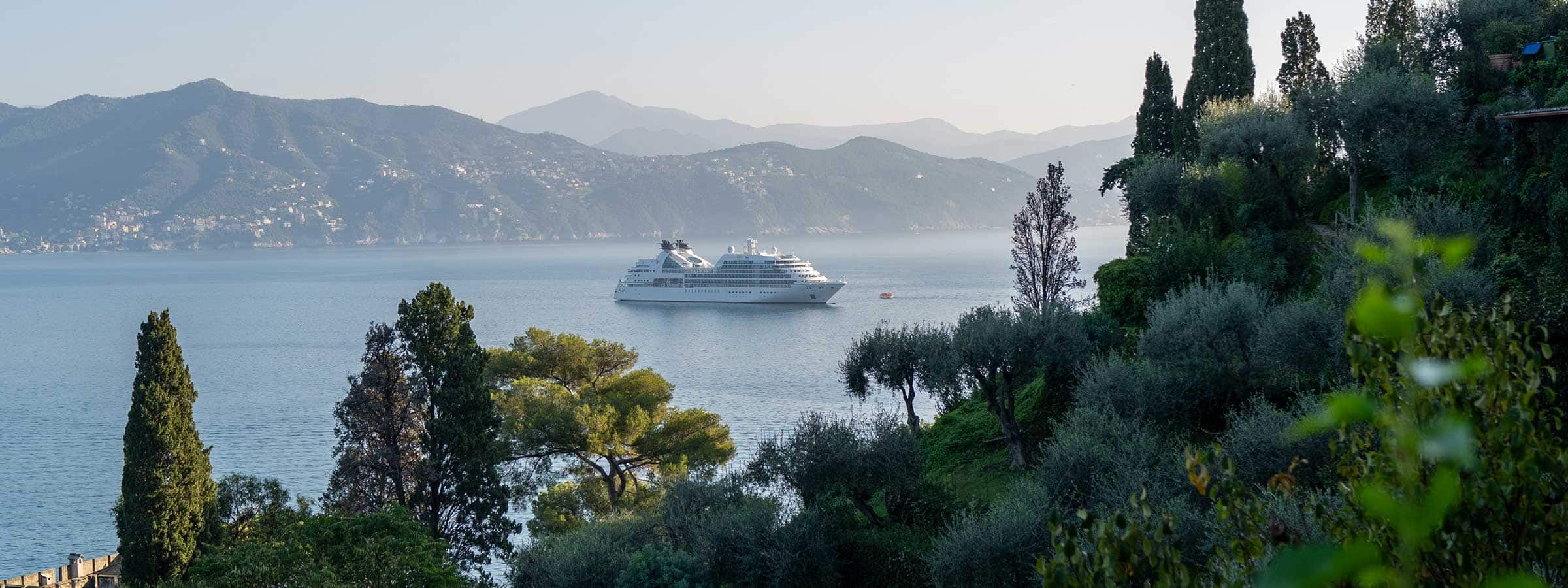 Seabourn Sojourn sailing through a scenic coastal bay